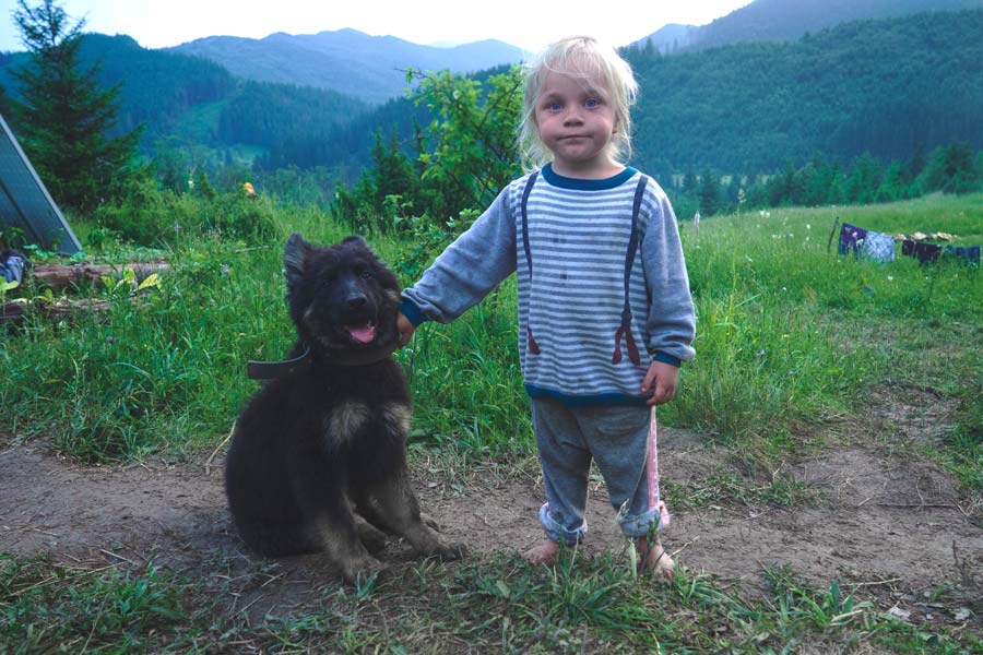 little girl outdoors with black dog