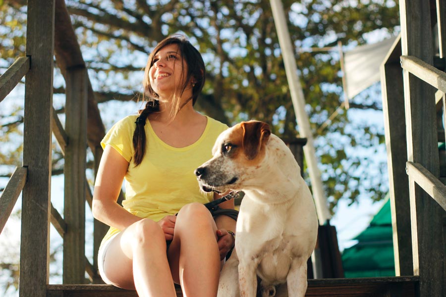woman sitting with dog, responsible pet owner