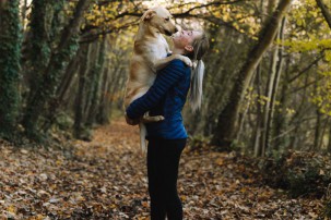 best pet sitter, woman holding dog in arms outdoors
