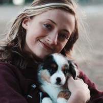 young woman holding puppy, caring for your pet