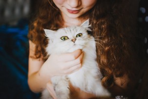 young girl holding cat, loss of a family pet